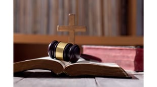 gavel on bible with cross in background